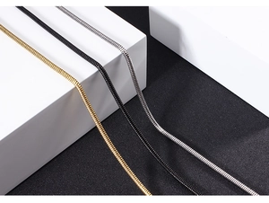 Detailed close-up of stainless steel snake chains in gold, black, and silver finishes