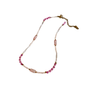Sweet pink and white bead necklace with agate pearls and gold accents on white background