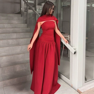 Detail of a red strapless maxi evening dress featuring a matching long elegant cape