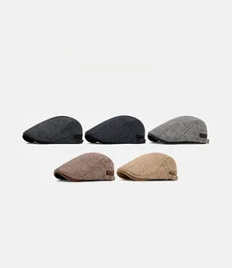 Detail of five plaid wool newsboy caps with side adjustable metal buckles in assorted colors