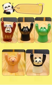 Close-up of five cute resin animal figurines including Daruma, black cat, and panda