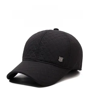 Détail d'une casquette d'hiver noire matelassée avec motif en losanges et emblème en métal