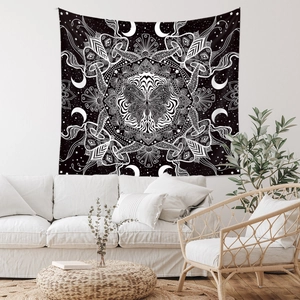 Macro detail of bohemian black and white mandala tapestry featuring butterfly and moon