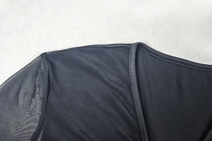 Detail of V-neck stitching with semi-transparent mesh and solid black stretch fabric