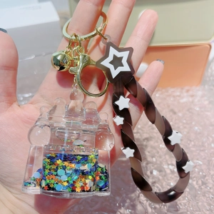 Luminous quicksand castle keychain with brown star lanyard and golden bell accent