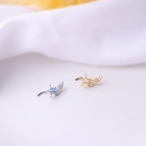 Detail of star-shaped nose studs in silver and gold with colorful zircon stones