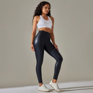 Detail of high waisted black faux leather yoga pants and white ribbed sports bra set