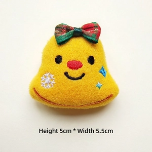 Detailed close-up of a 5cm plush yellow Christmas bell accessory with a plaid bow tie