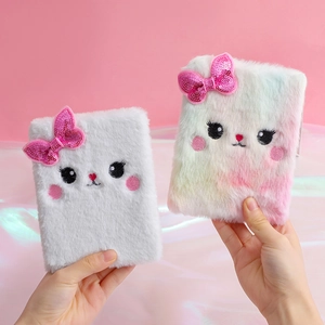 Detail of cute plush cat journals in white and rainbow colors with sequin bows