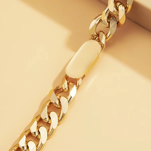 Macro shot of gold-plated chunky curb chain necklace with a polished rectangular plate