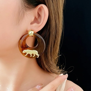 Retro amber hoop earrings with gold leopard embellishment on model with black background