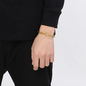 Nahaufnahme eines goldenen Edelstahl-Gliederkettenarmbands mit OT-Verschluss am Handgelenk