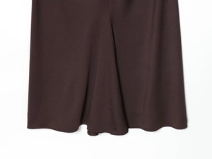 Detail shot of the deep brown dress hemline showing smooth drape and quality stitching