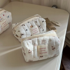 Detailed view of quilted cotton cosmetic bags featuring bear and bow cartoon prints