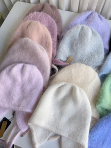 Detail von Angora-Kaninchenhaar-Strickmützen mit Ohrenklappen in verschiedenen Morandi-Farben