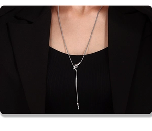 Detail of silver snake-shaped pendant necklace with unique head and tail clasp design