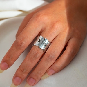 Nahaufnahme verstellbarer silberner Lorbeerblatt-Ring mit Federstruktur an der Hand