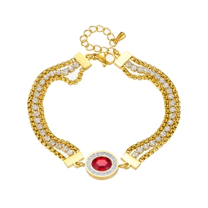 Three-layer gold chain bracelet with red gemstone pendant and white crystal accents