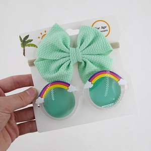 Mint waffle bow headband and rainbow cloud sunglasses set on a display card