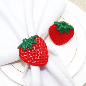 Gros plan de ronds de serviette en fraise rouge sur tissu blanc et assiette