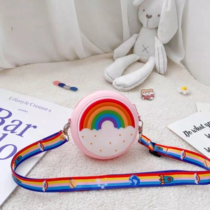 Detail of pink silicone donut bag with rainbow strap on a soft white texture