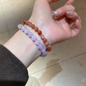 Detail of double-layer beaded bracelet with purple, orange, and red natural stones