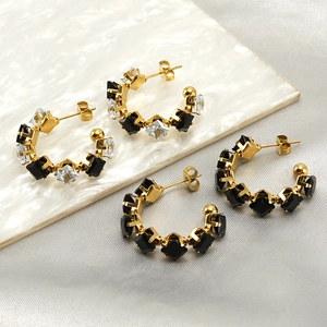 Elegant C-shaped gold plated earrings with black and white zircon gemstones on silk
