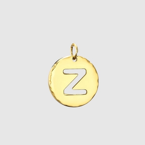 Macro view of gold stainless steel round pendant with letter Z and hammered texture