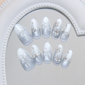 Faux ongles amande longs avec dégradé bleu oeil de chat et détails de nœuds papillons 3D