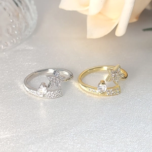 Minimalist silver and gold star rings with sparkling micro-pave crystals on white satin