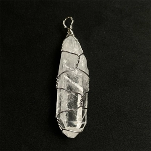 Natural clear quartz point pendant with silver wire wrap on black textured background