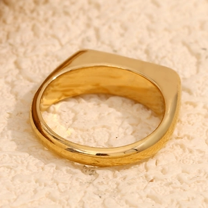 Macro shot of polished 18K gold plated stainless steel signet ring with a smooth finish