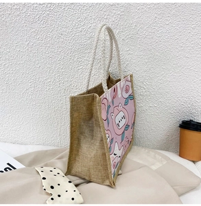 Detail of jute tote bag showing natural woven texture and cute cartoon cat printing