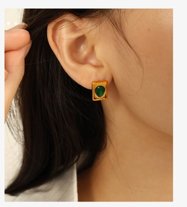 Close-up of 18K gold plated emerald green teardrop earring worn by a model