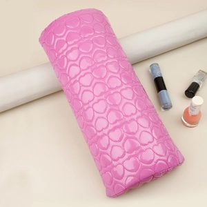 Detail of bright pink PU leather nail arm rest with quilted heart texture and nail polish