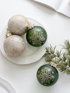 Detail of Christmas tree ornaments with green matte snowflake and champagne glitter finish