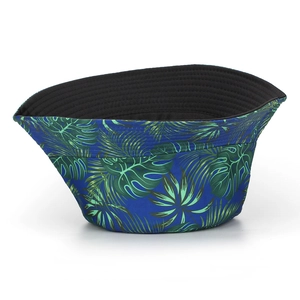 Unisex bucket hat with tropical leaf print and reversible black design for sun protection