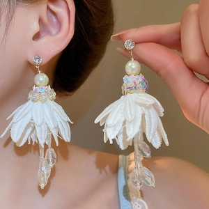 Detail of white chiffon flower earrings with rhinestones, pearls and beaded tassels