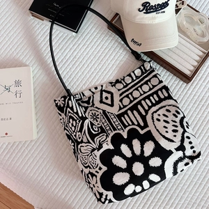 Flat lay of bohemian black and white floral canvas tote bag with thin leather straps