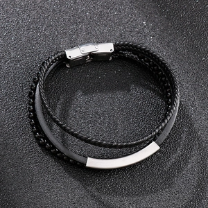 Detail of multi-layer men's leather bracelet with silver curved plate and magnetic clasp
