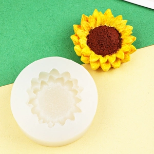 Sunflower silicone mold and finished yellow flower candle on a dual-tone paper background