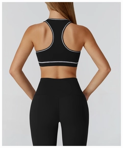 Rear view of black racerback sports bra with white trim and matching high-waisted leggings