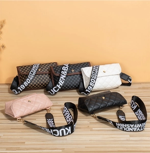 Quilted cross-body bags with wide printed straps displayed on a wooden surface