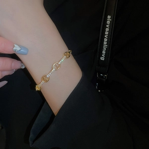 Macro shot of gold plated oval bracelet with shimmering cubic zirconia on a woman's wrist