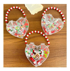 Close-up of heart-shaped Christmas gift boxes with festive beads and Santa charms