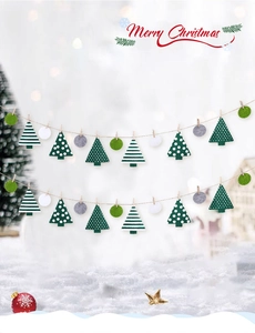 Detail der Weihnachts-Filzgirlande mit grün-weißen Bäumen vor winterlicher Szenerie