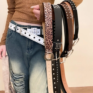 Détail de ceintures en cuir élégantes avec œillets métalliques, rivets et boucles rondes