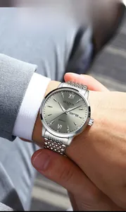 Business style close-up of a men's luminous steel watch with double calendar on a wrist