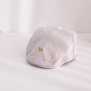 Détail de béret rayé pour bébé avec broderie chien marron et ombre de persienne