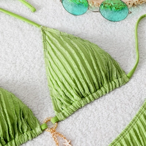 Macro shot of green textured bikini with gold starfish charm and chain details
